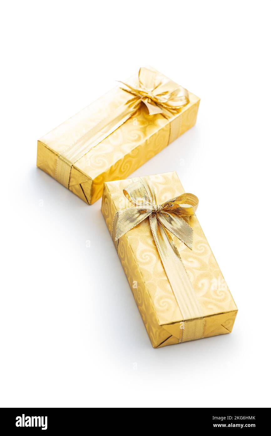 Gift wrapped in gold foil. Christmas present with gold ribbon isolated on the white background. Stock Photo