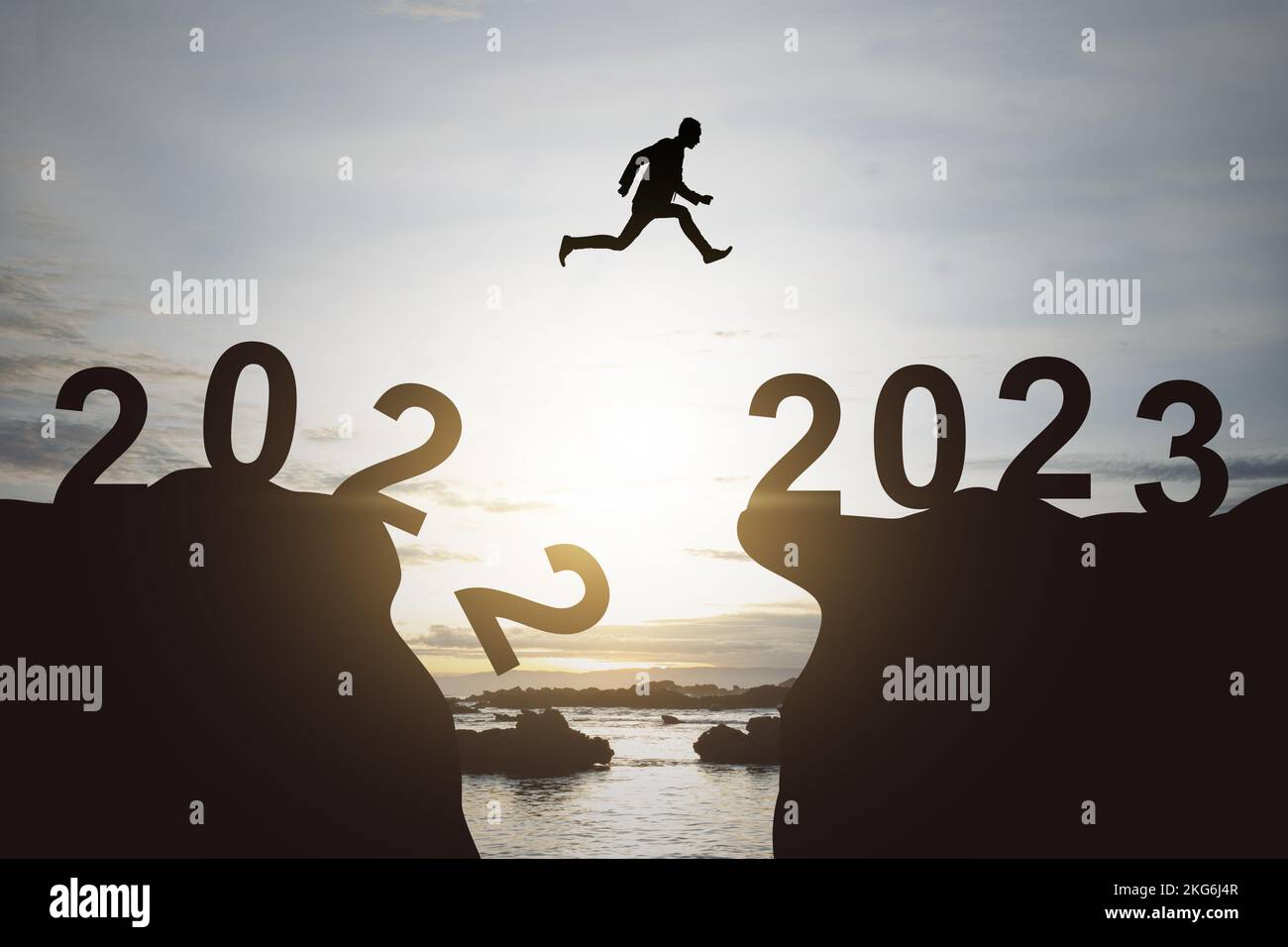 Silhouette of a businessman jumping from 2022 hill to 2023 hill. Happy ...