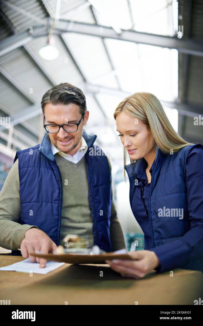 They never fail to deliver. a two coworkers managing a warehouse. Stock Photo