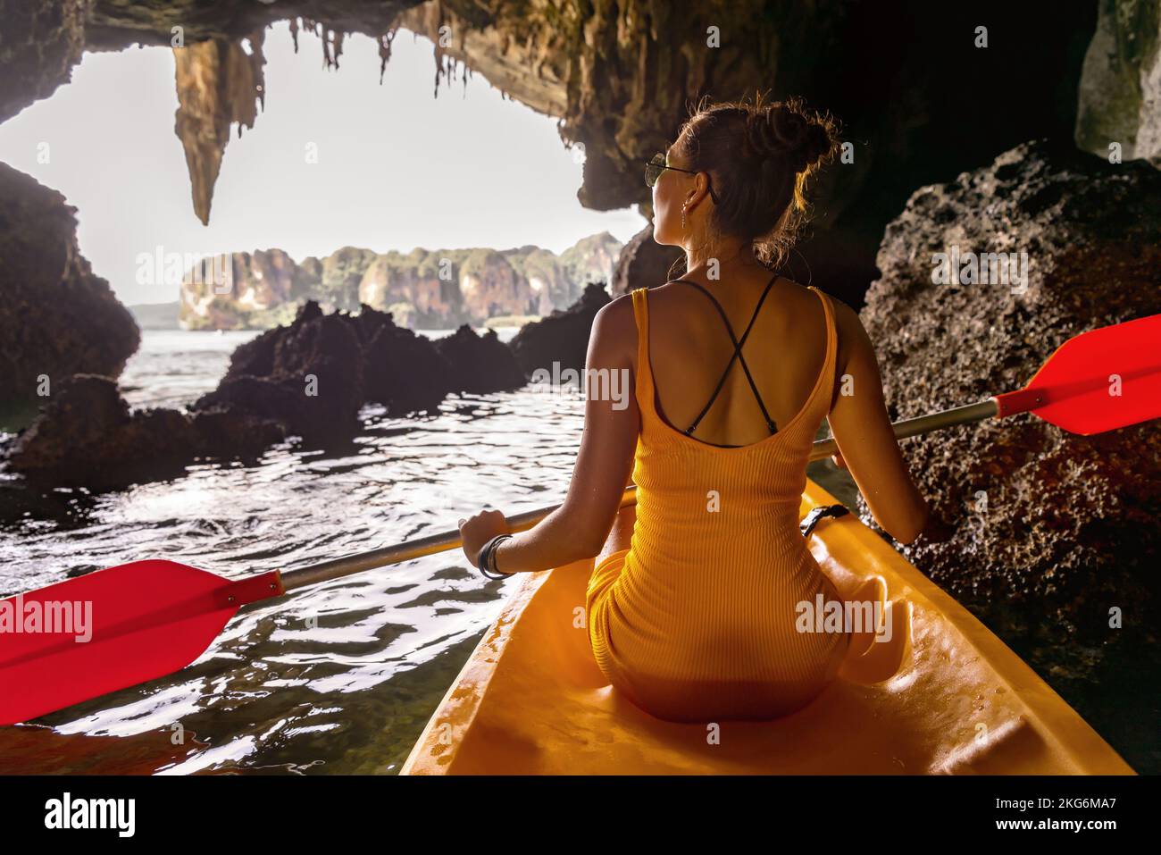 Beautiful girl is walking on kayak or canoe at sea bay. Tropical resort vacations Stock Photo