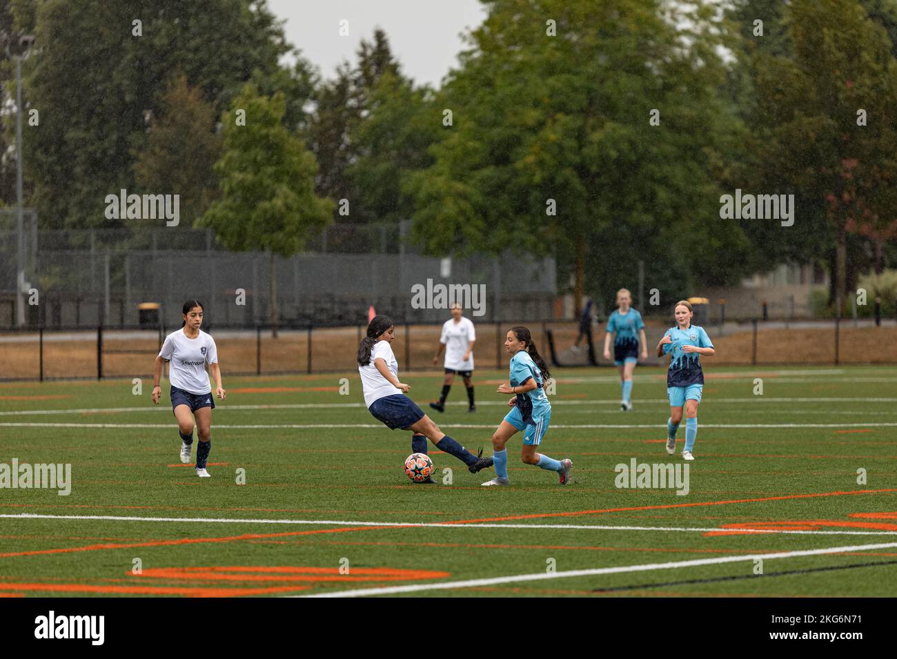 Children soccer players playing game. Young girls soccer players participating in local championship on grass football field-Surrey BC Canada-October Stock Photo