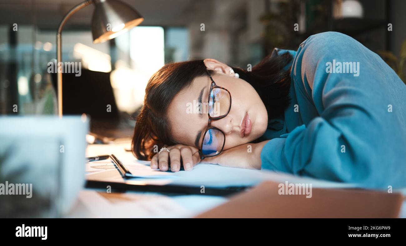 Tired, burnout and sleep with a business woman sleeping on desk while working on a computer at a desk in his office. Mental health, problem or Stock Photo