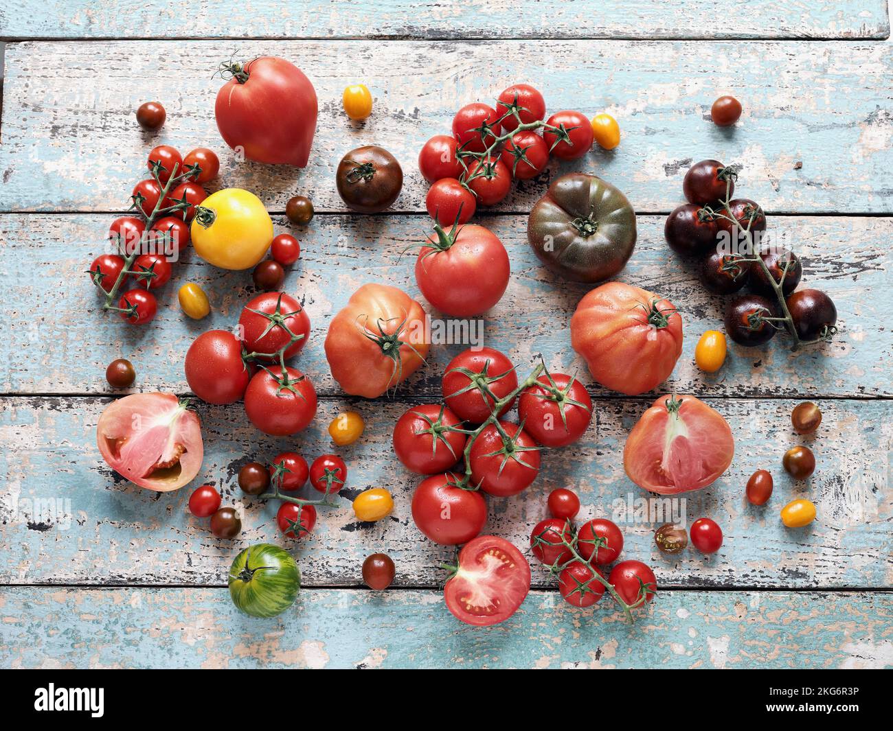 Still life variety of tomatoes on rustic background Stock Photo - Alamy