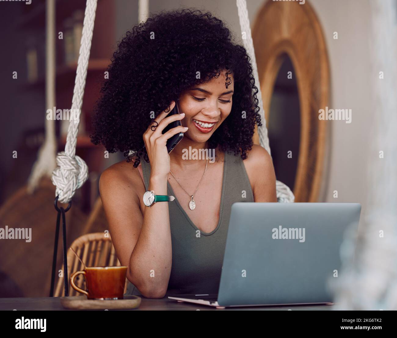 Black woman, phone call and laptop, internet cafe and remote work, planning and blogging as freelancer entrepreneur. Happy young female talking on Stock Photo