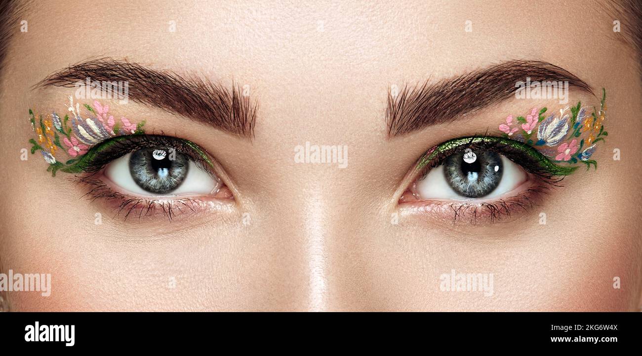 Female eye with flower makeup eyes. Spring makeup. Beauty fashion. Eyelashes. Cosmetic Eyeshadow. Make-up detail. Close up, Macro Stock Photo