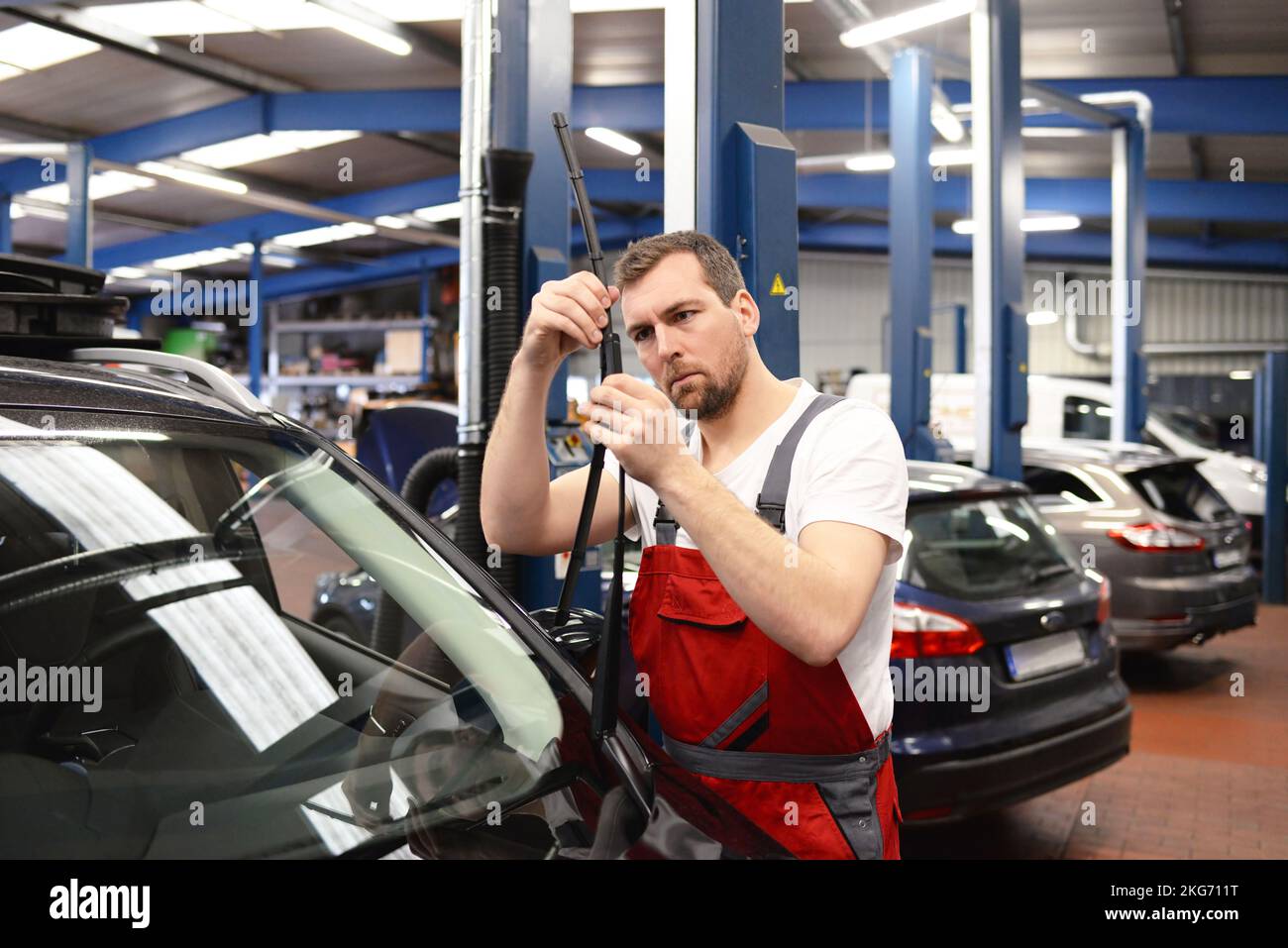 mechanic in a car repair shop inspected the condition of the windscreen wiper for wear and tear to ensure safety Stock Photo