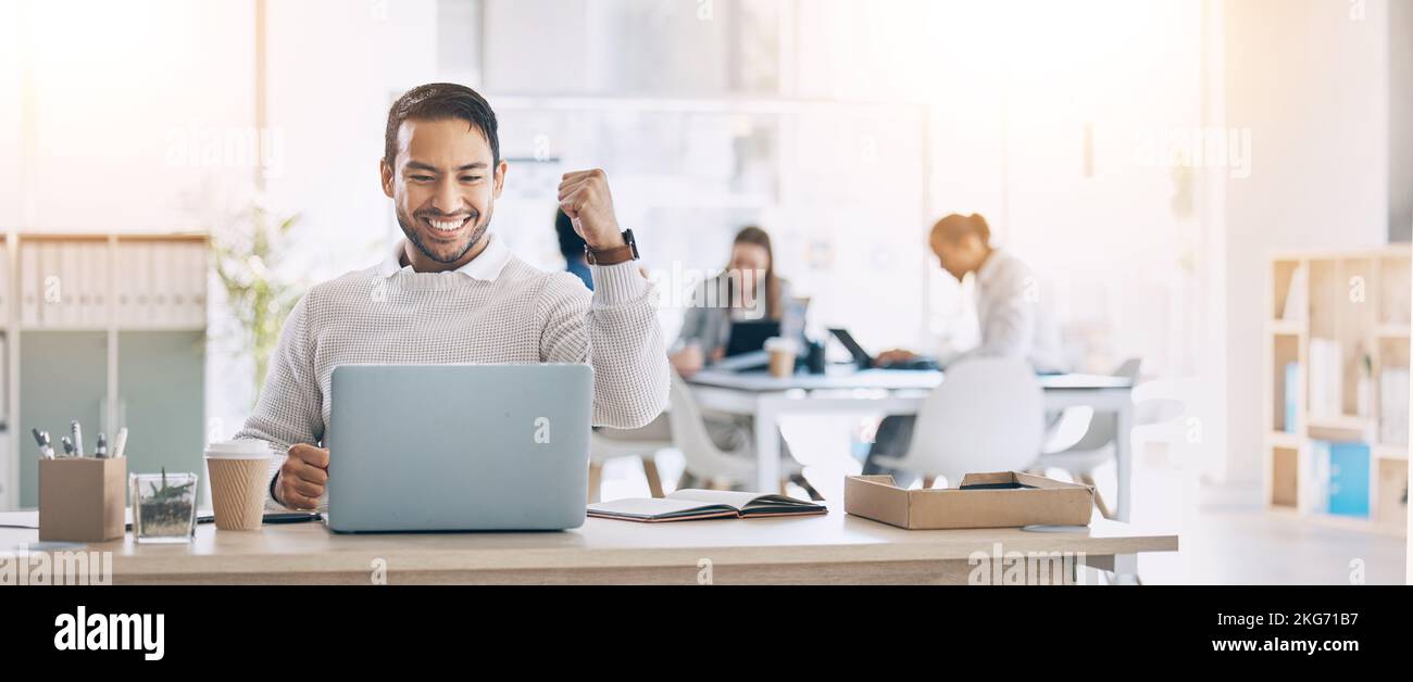 Man, laptop and celebrate at office desk for success, deal or crypto on internet at startup. Winner businessman, computer or smile for winning Stock Photo