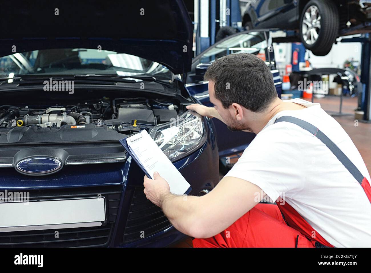 adjusting the headlights on the car by mechanics in a garage Stock Photo