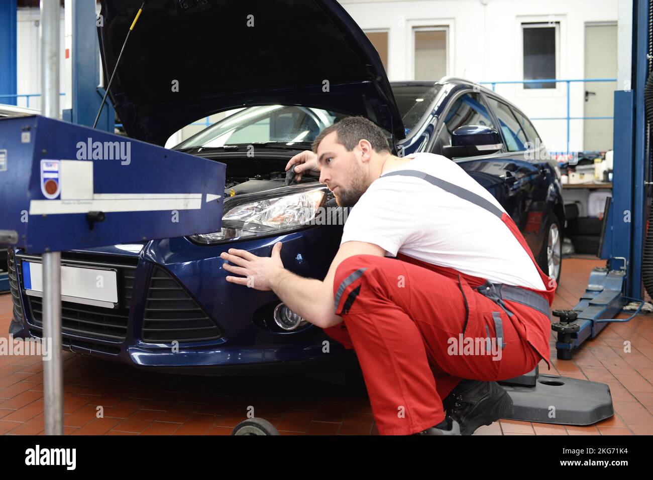 adjusting the headlights on the car by mechanics in a garage Stock Photo