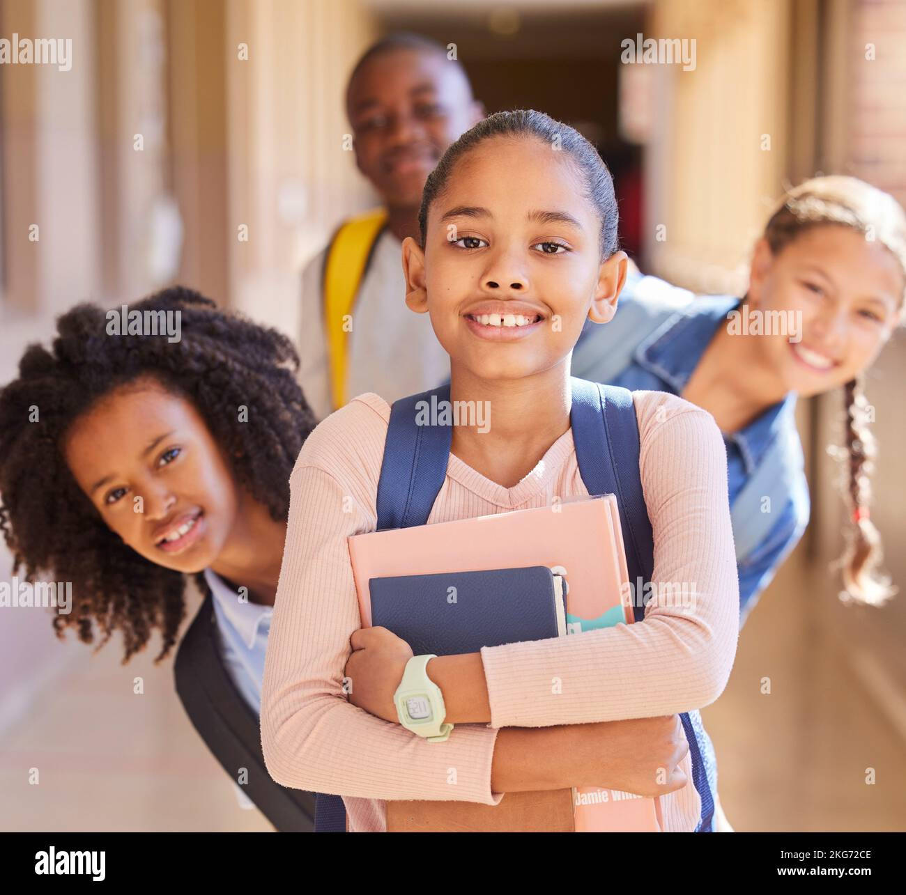 Education, children and portrait of friends at school together standing in the hallway for class. Diversity, backpack and happy students with a smile Stock Photo