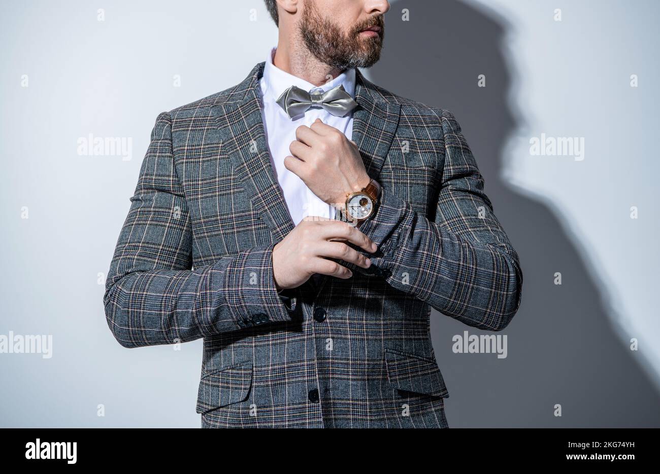 photo of guy wearing tuxedo and wristwatch. guy wear tuxedo formal suit