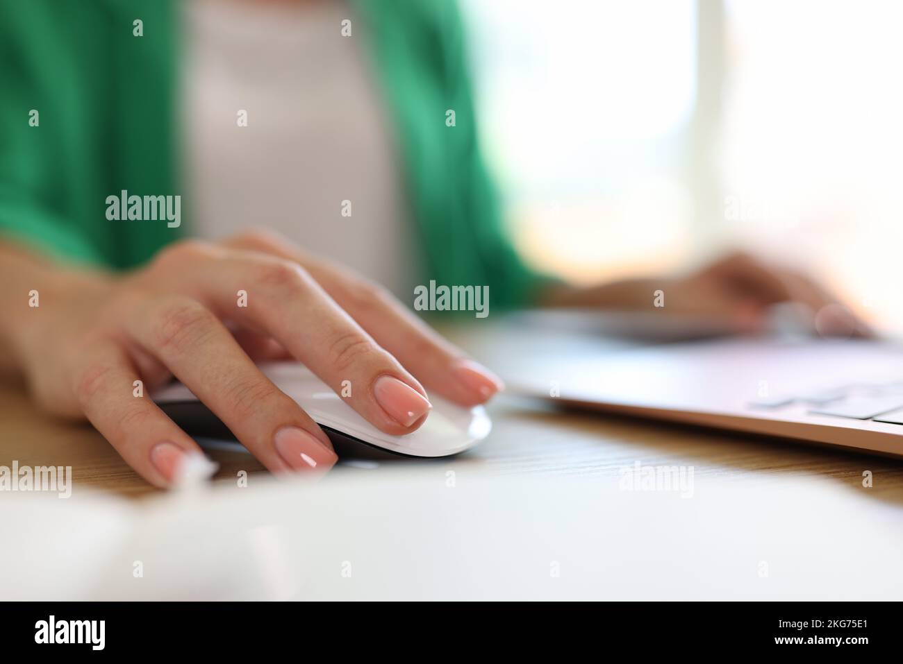 Woman using computer mouse working on modern laptop in office Stock Photo