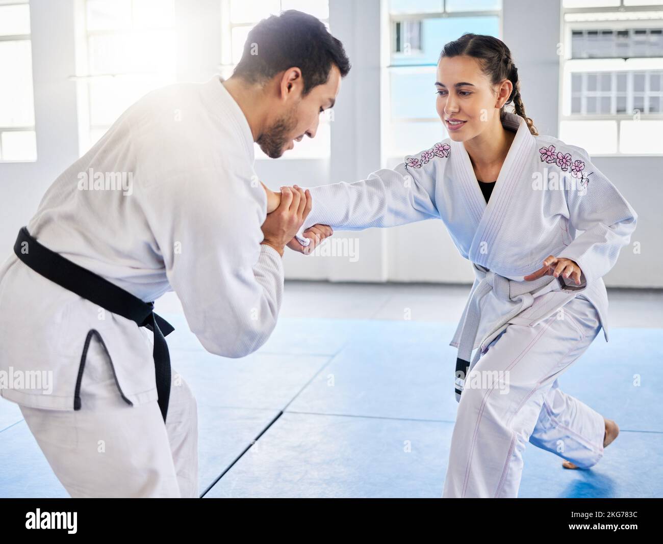 Man, karate and coach training woman in fitness, workout and exercise class for competition, black belt fight or self defense. Sports athlete, judo Stock Photo