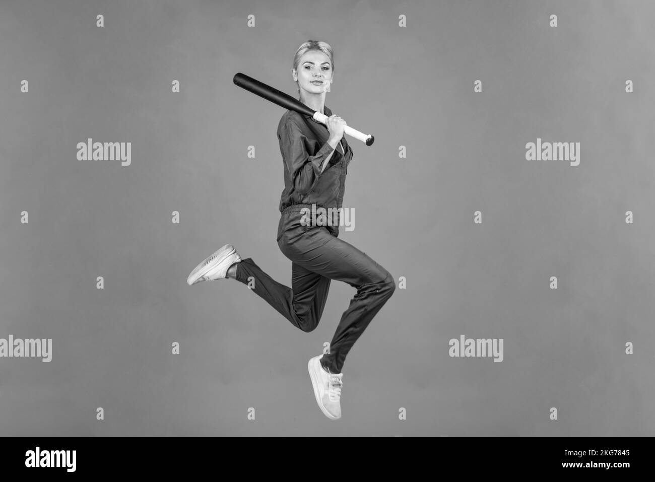 woman jump in uniform hold baseball or cricket bat sport game equipment