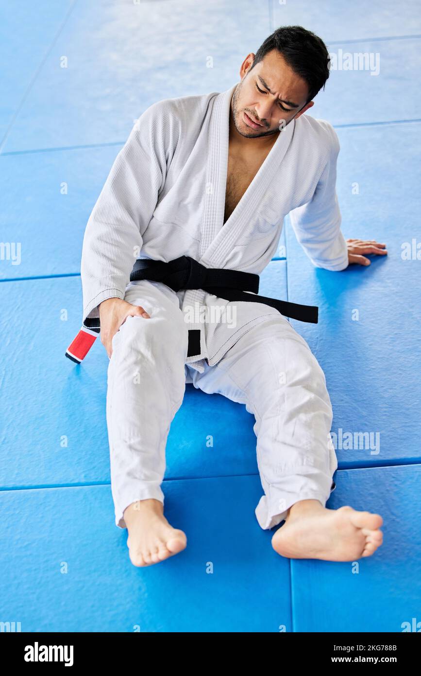 Sports, injury and pain in legs on karate fitness dojo floor for