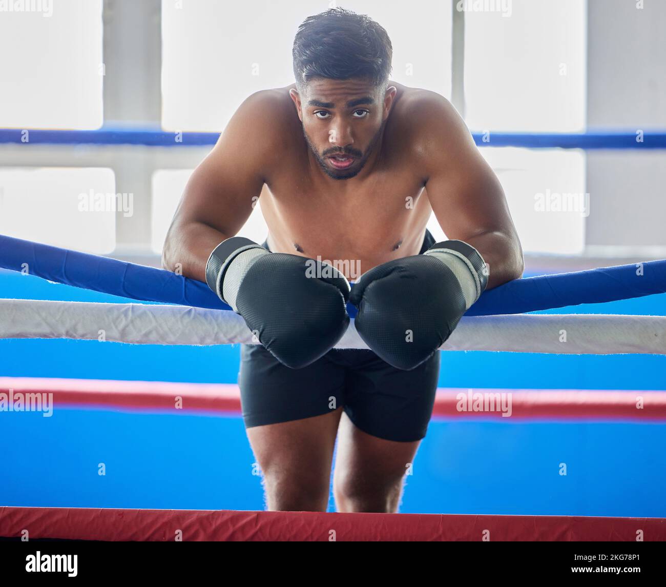 Boxing ring, man and tired from fight, training and workout in gym exercise, burnout and fail in competition games. Portrait sweating boxer, athlete Stock Photo