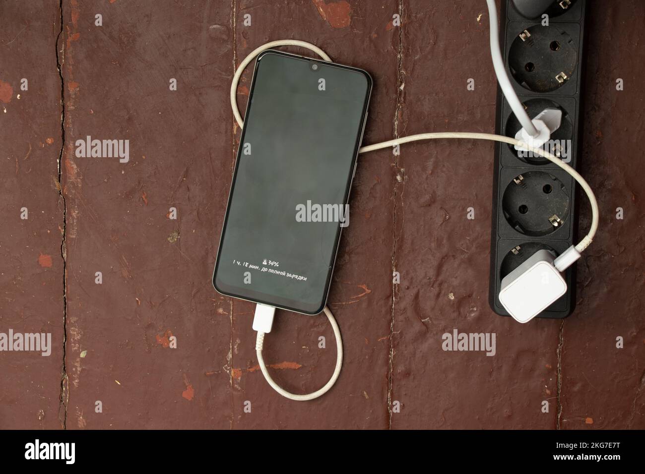 the phone is charging near the socket on the table, charging the phone