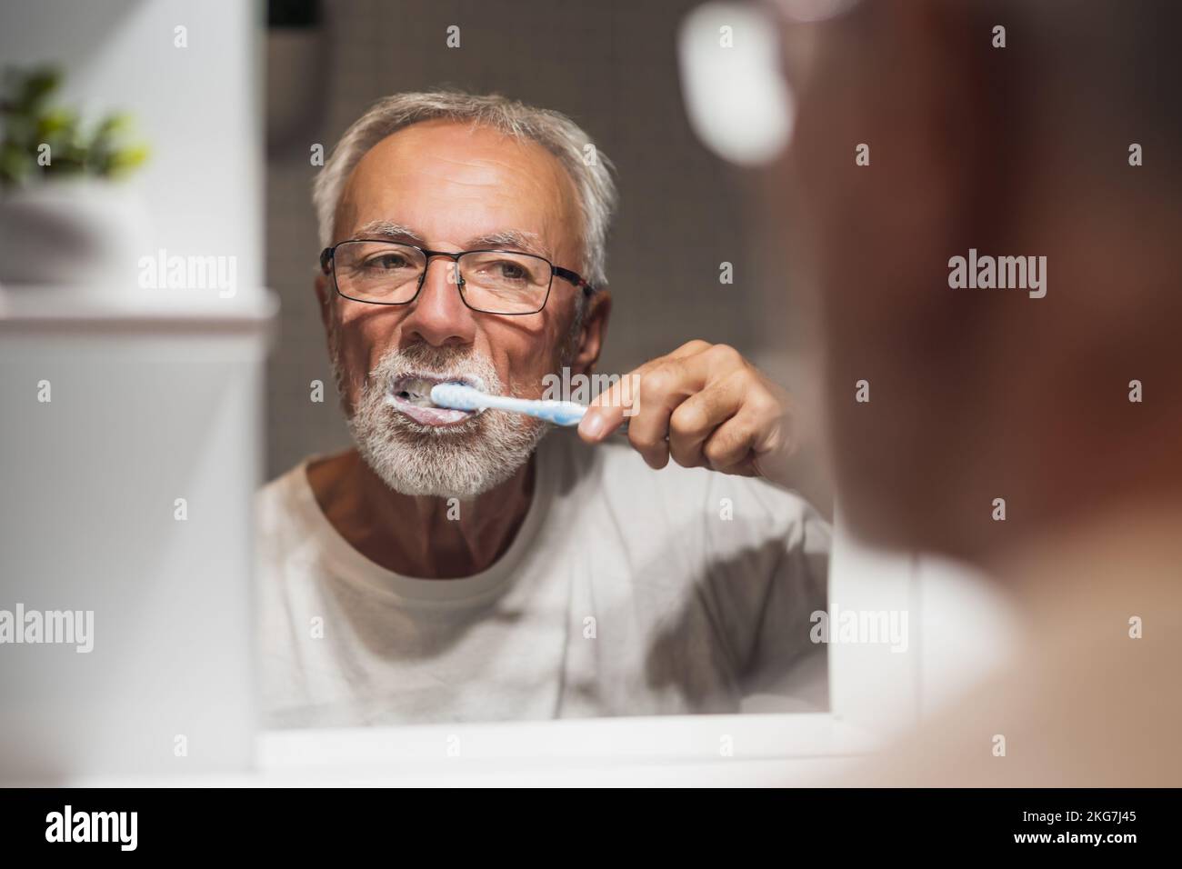 Senior man is cleaning his teeth in bathroom. Dental hygiene Stock ...