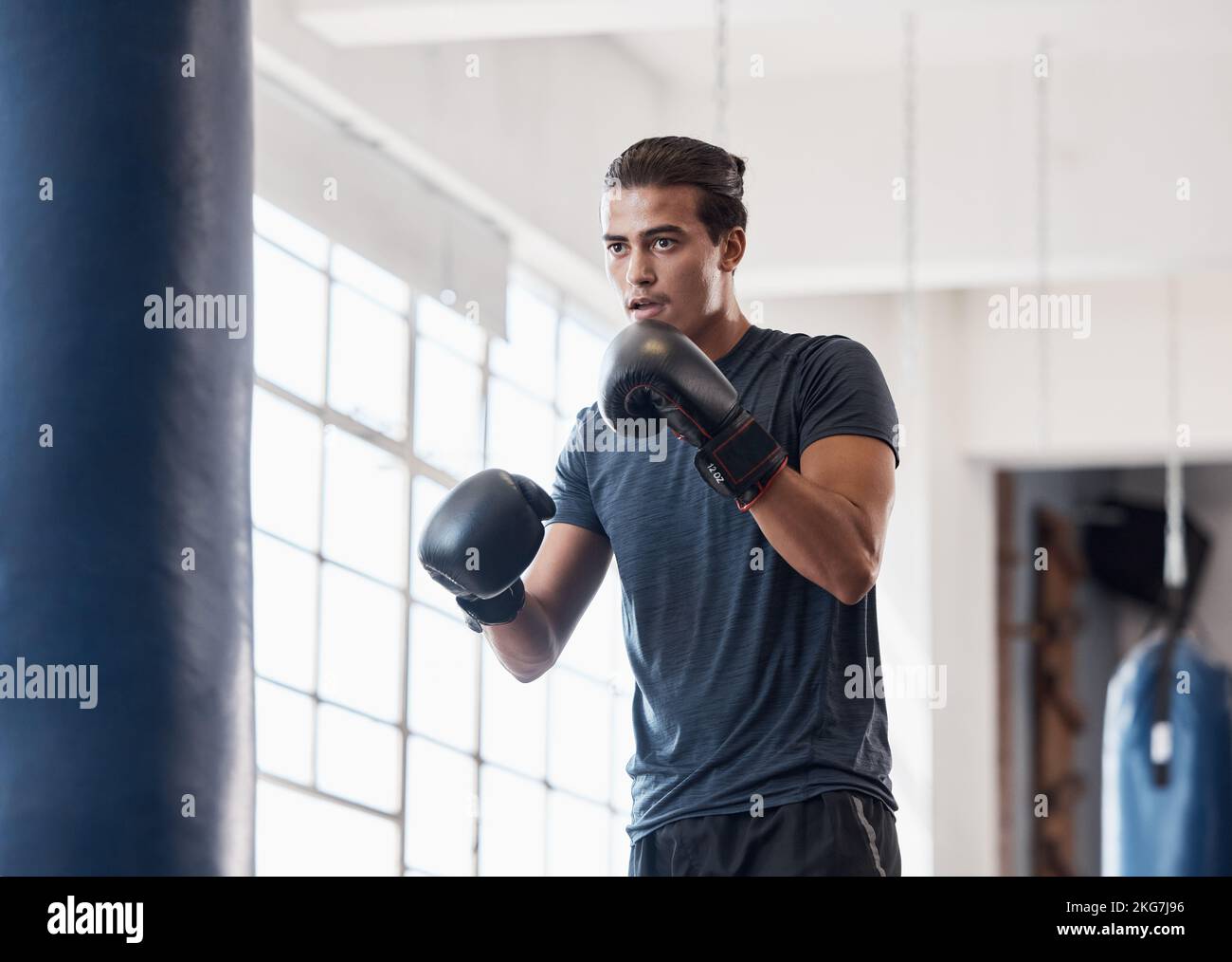 Fitness, training and boxing with man in gym for workout, exercise and sports stamina. Cardio, energy and power with athlete and punching bag for Stock Photo