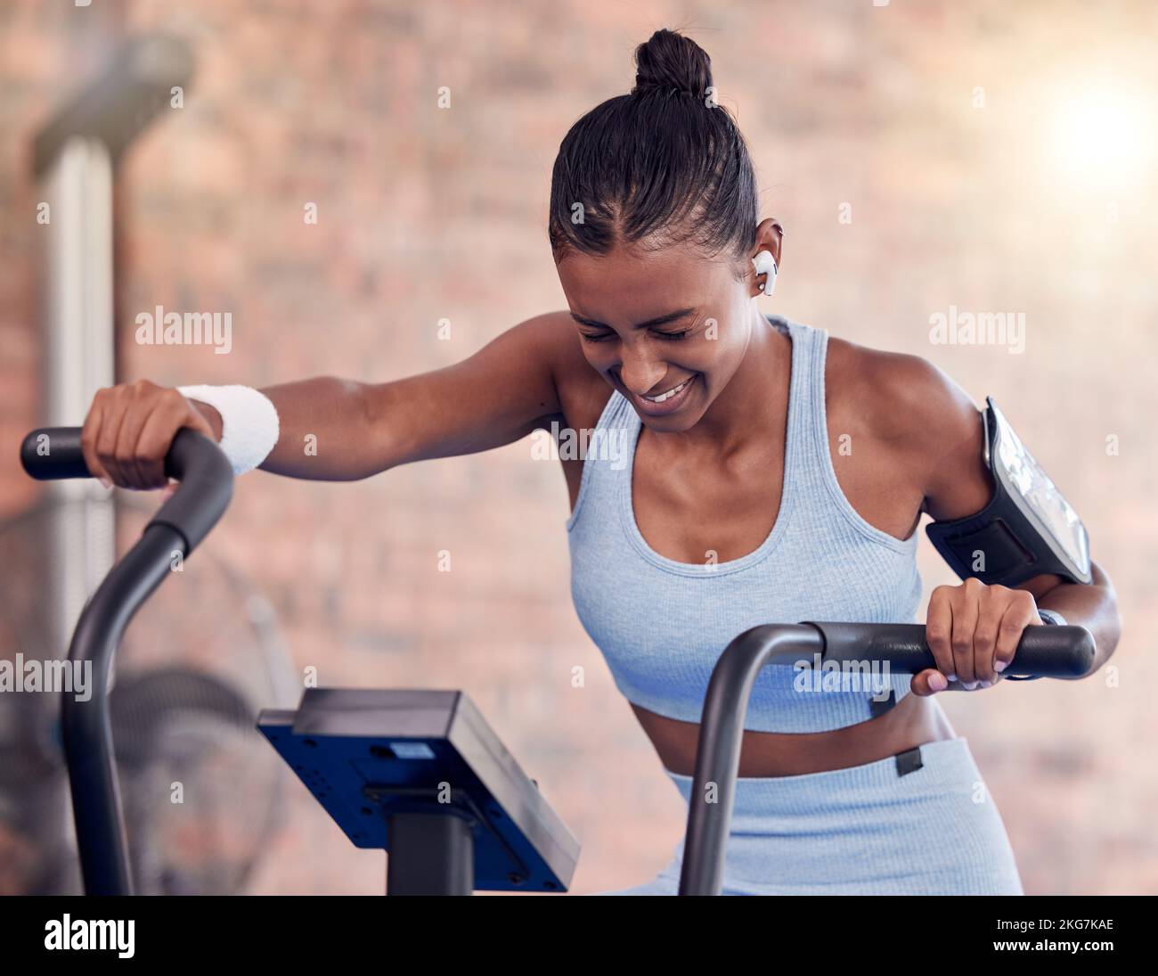 Fitness, woman and intense cycling at the gym for exercise, workout or healthy cardio training. Active female exercising on stationary bicycle or Stock Photo