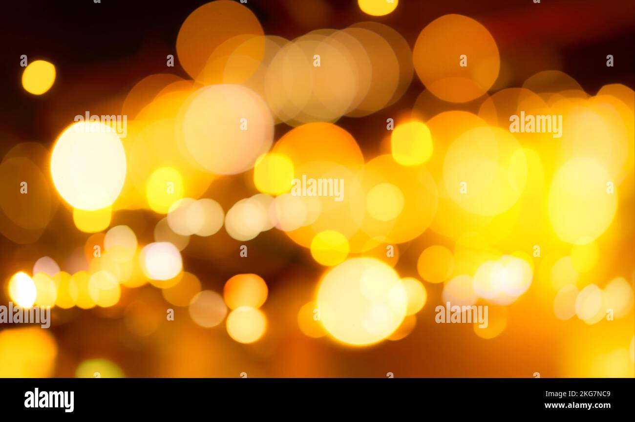 Blur gold color bokeh background. Blur abstract background of city light. Warm light with beautiful pattern of round bokeh. Orange festive light Stock Photo