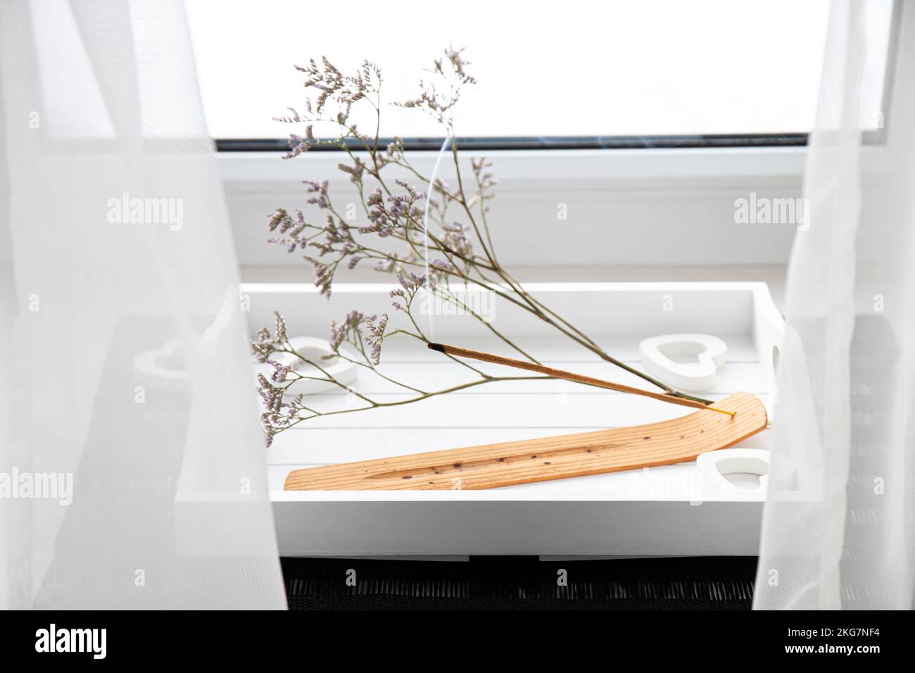 Scent Styling concept. Home window sill with incense candle burning on white minimal tray, create good mood with good pleasant scent. Stock Photo