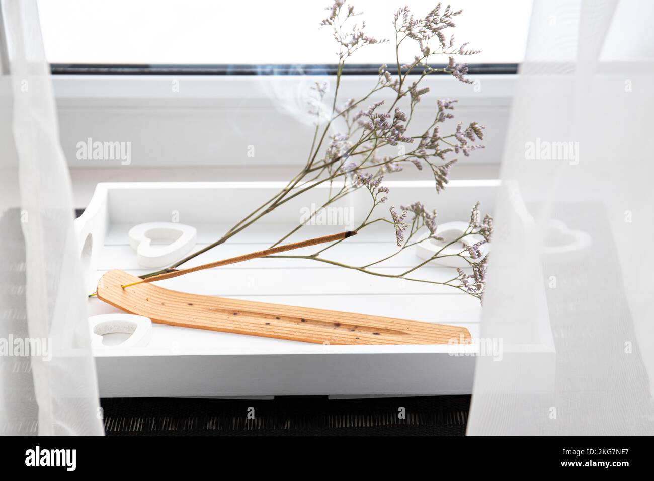 Scent Styling concept. Home window sill with incense candle burning on white minimal tray, create good mood with good pleasant scent. Stock Photo