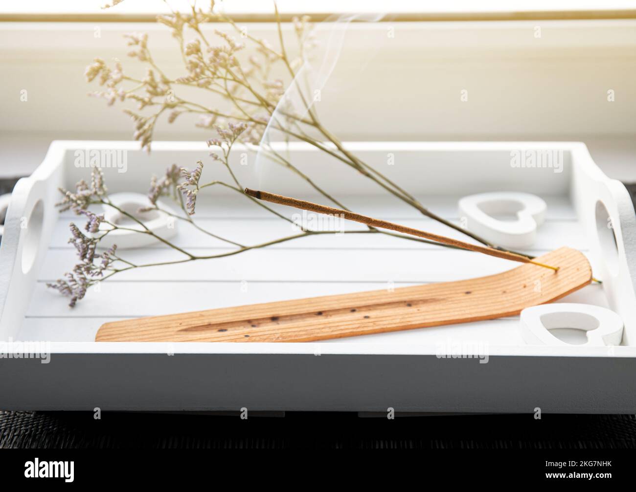 Scent Styling concept. Home window sill with incense candle burning on white minimal tray, create good mood with good pleasant scent. Stock Photo