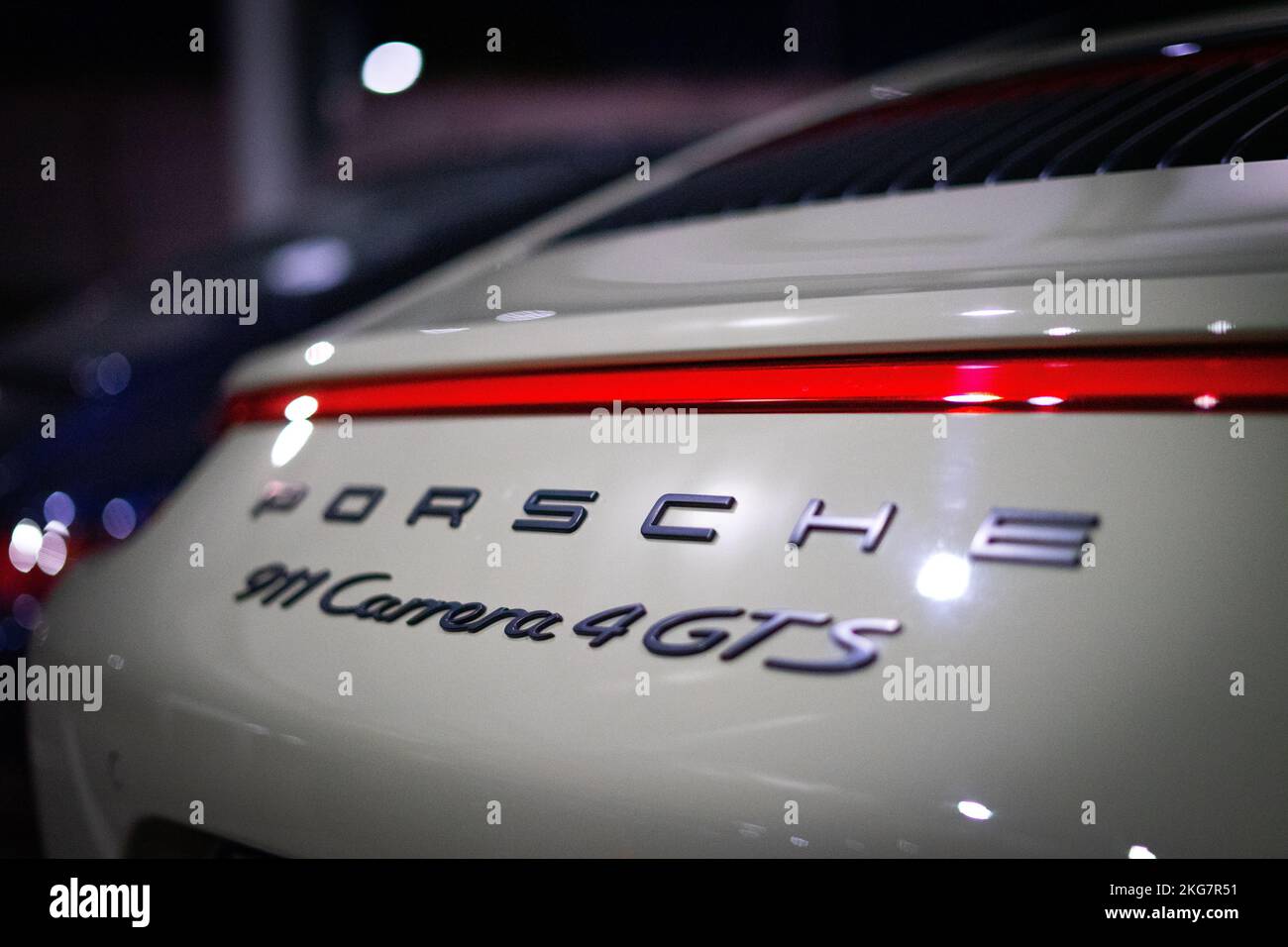 A closeup of the Porsche 911 Carrera 4 GTS car rear in artificial light. Stock Photo