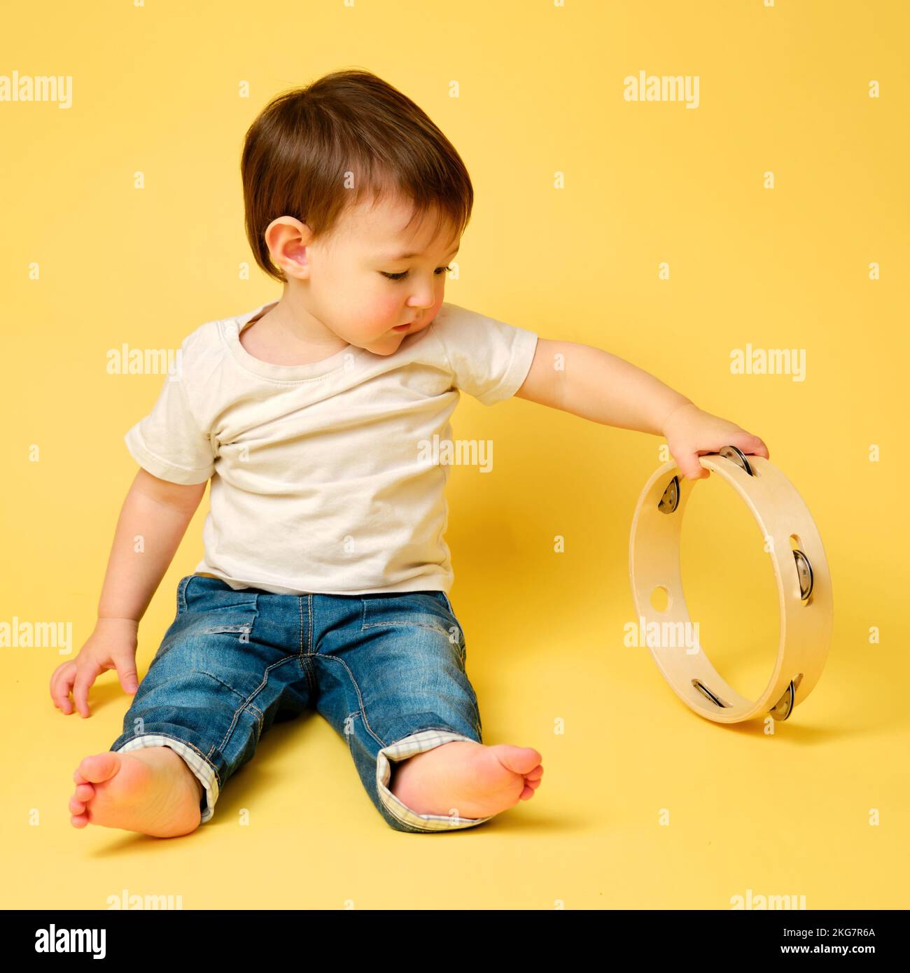 Toddler baby plays the tambourine, a child with a percussion musical