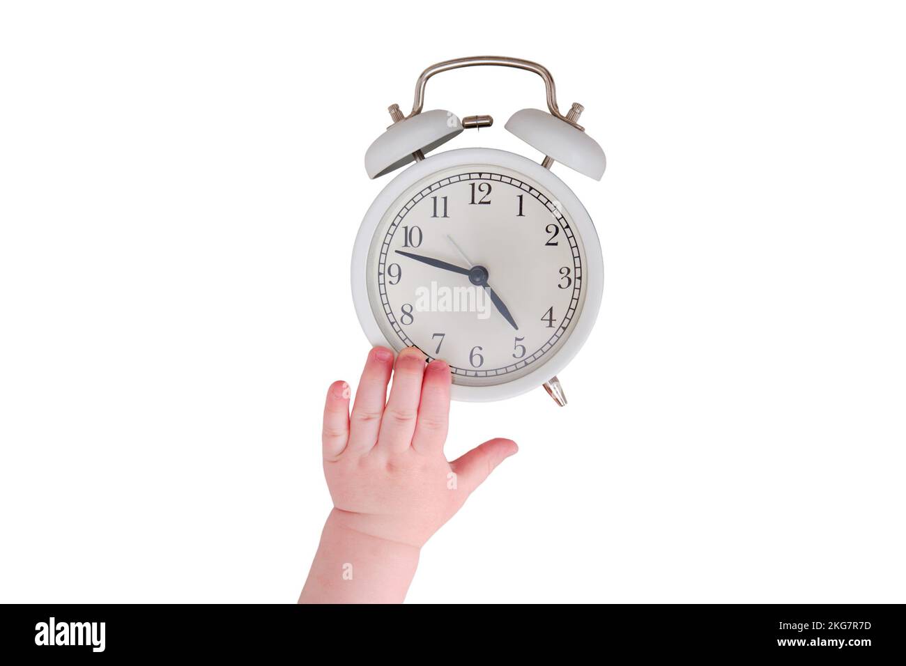 Baby toddler boy holds an alarm clock in his hand, isolated on a white
