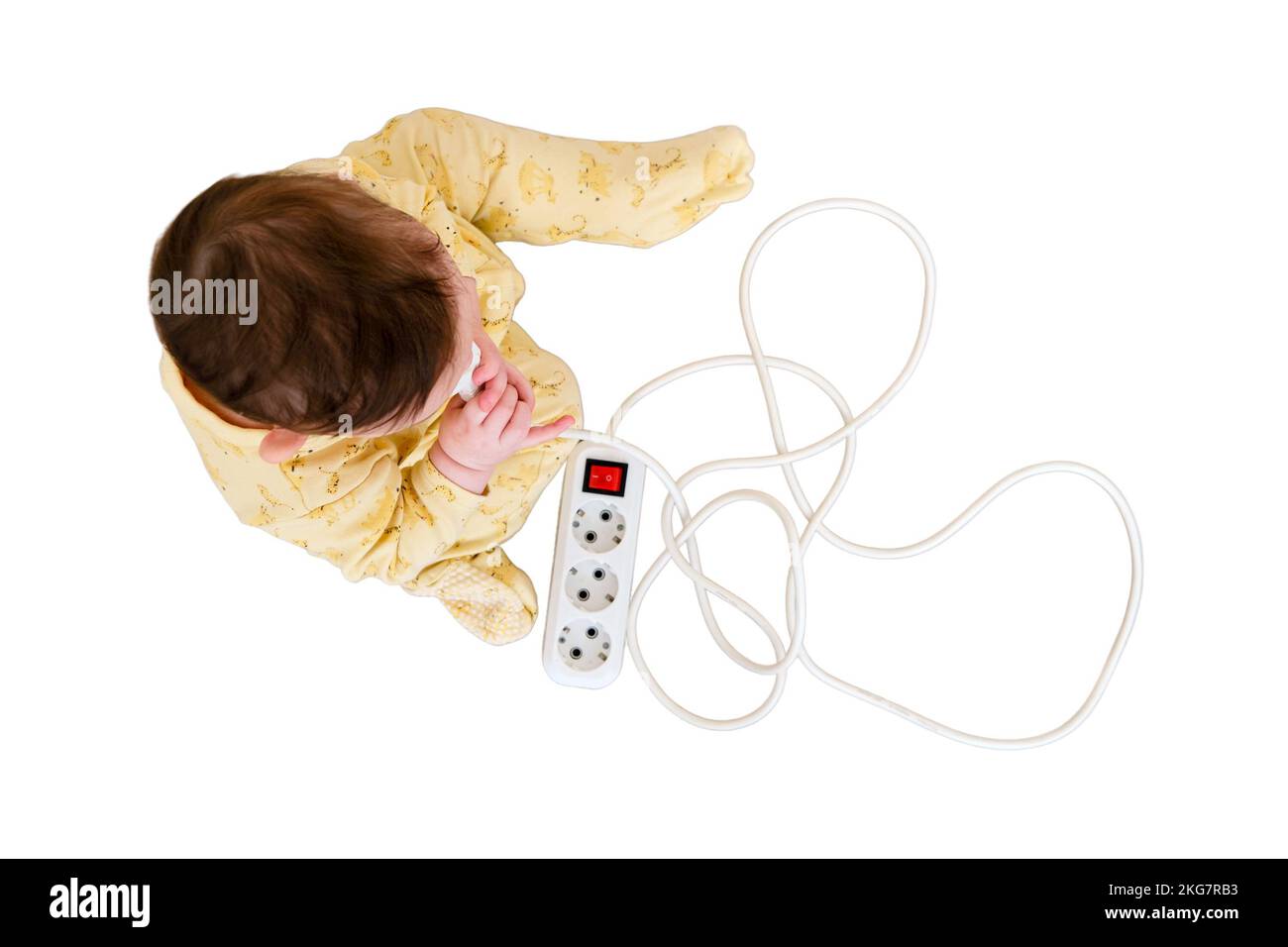 Toddler baby boy plays with electric wires while sitting on the floor