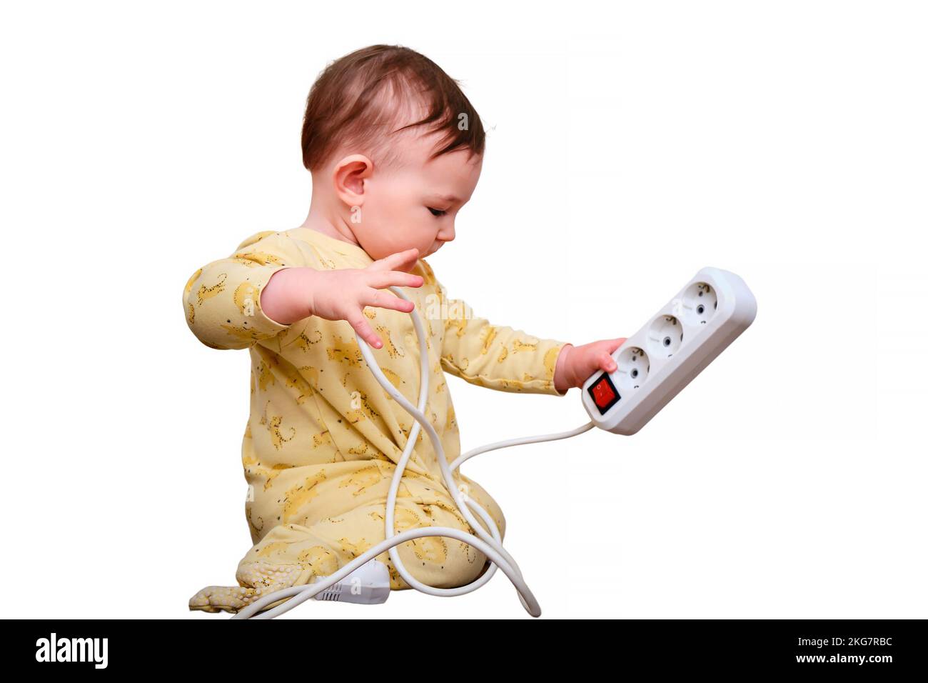 Toddler baby boy plays with electric wires while sitting on the floor