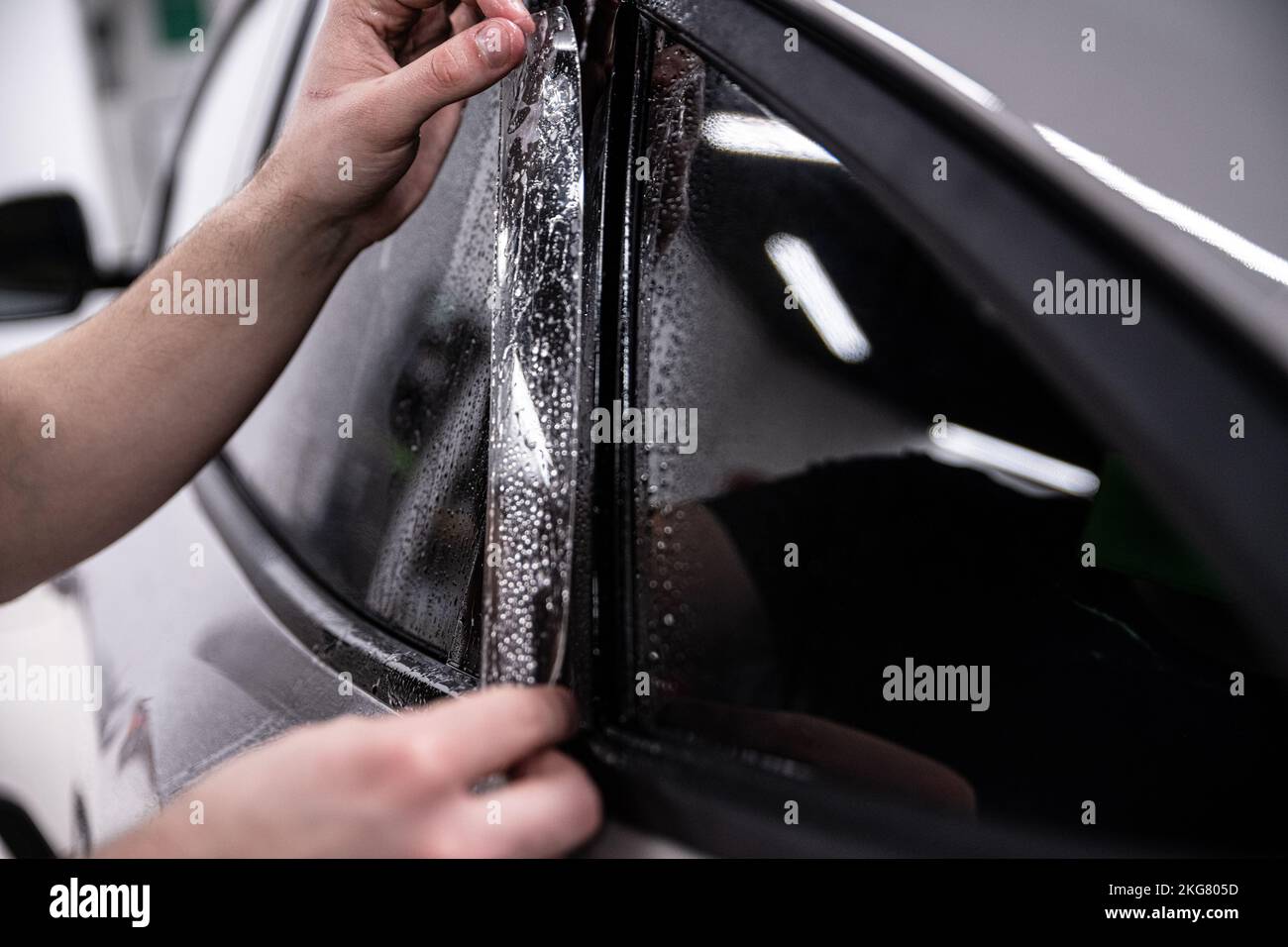 Car Color Less Employee of a car wash or a car detailing studio applies a colorless ...