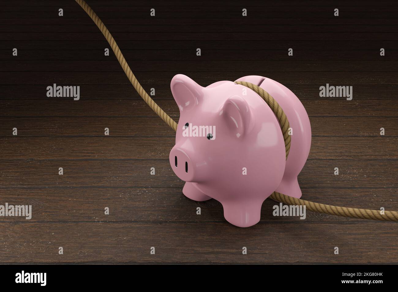 Pink piggy bank is tightened by a rope on wooden table. Illustration of the concept of budget tightening and reduction of spending Stock Photo