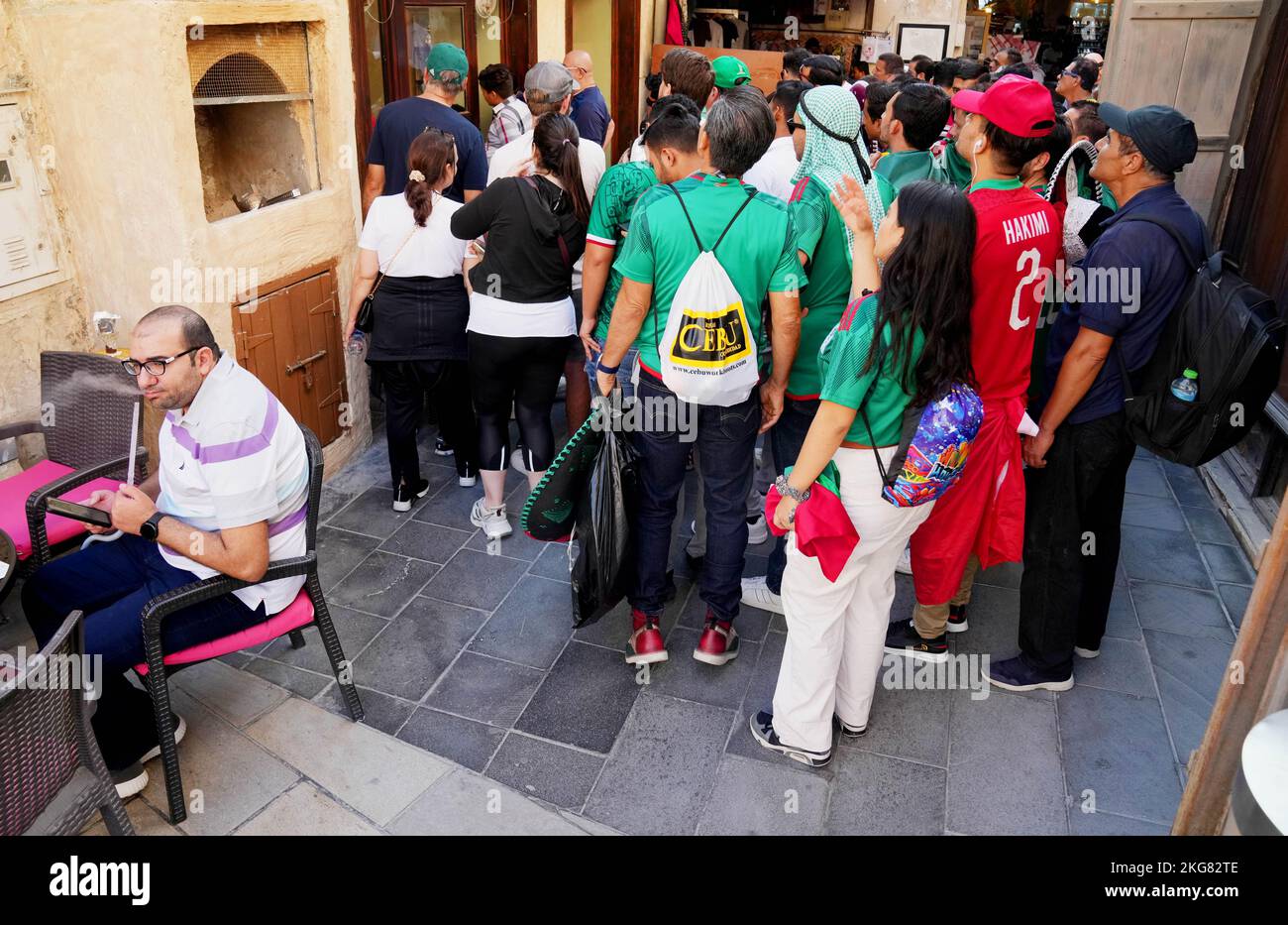 Mexican football fans and others strain to watch the match between