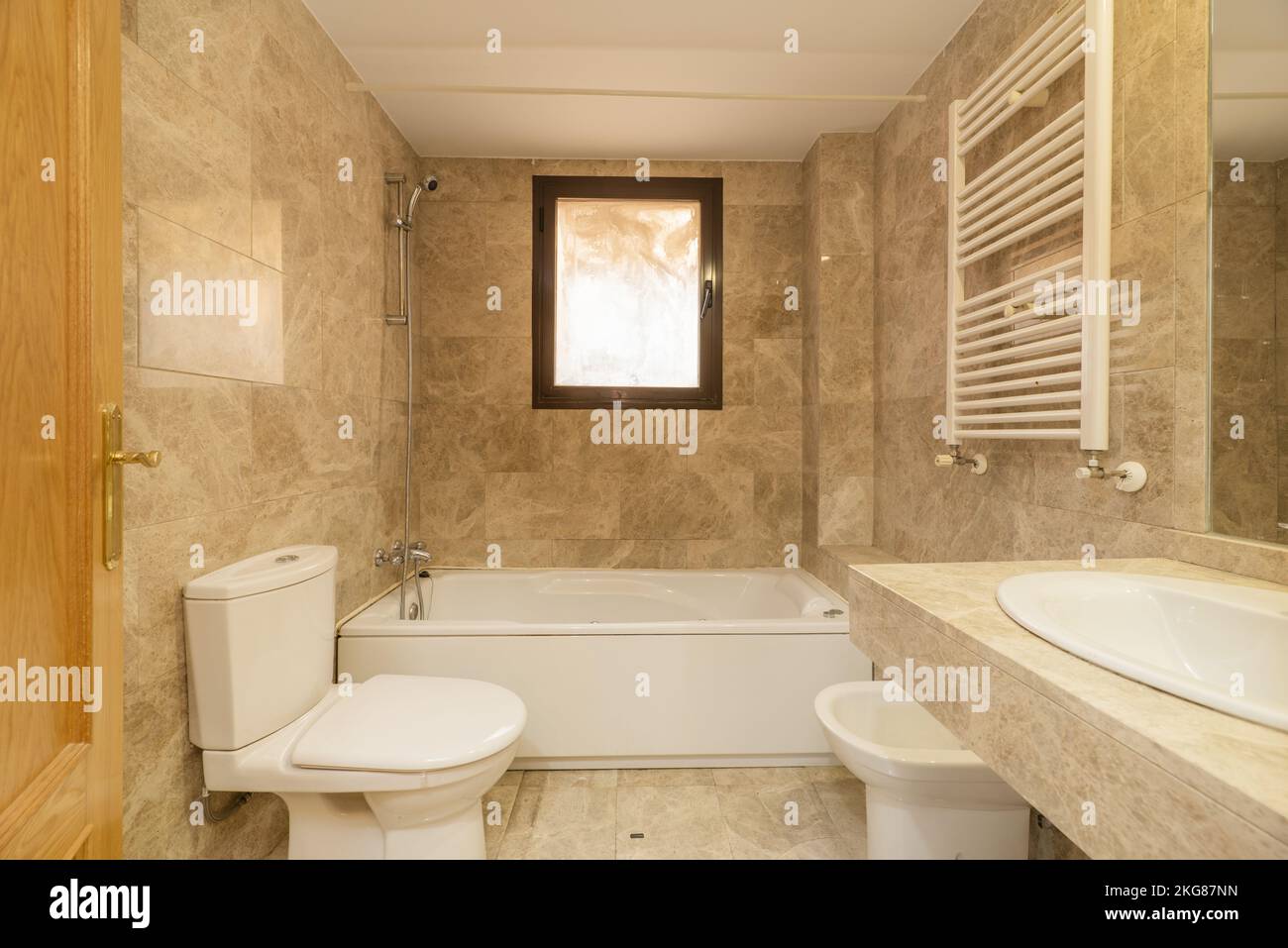 Bathroom with mirrors clad in marble, cream marble floors with matching