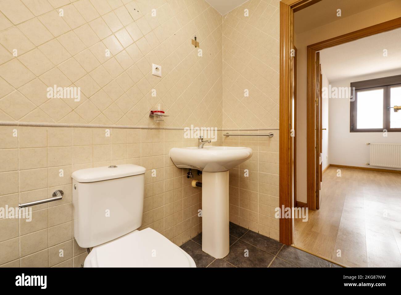 Small cloakroom with pedestal porcelain sink and square tiled walls and