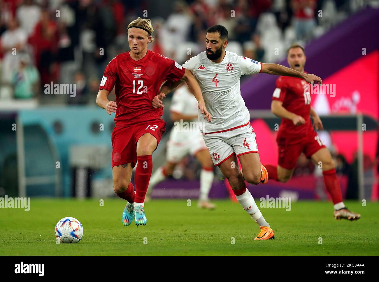 Denmark’s Kasper Dolberg (left) and Tunisia's Yassine Meriah battle for the ball during the FIFA World Cup Group D match at Education City Stadium, Al Rayyan, Qatar. Picture date: Tuesday November 22, 2022. Stock Photo