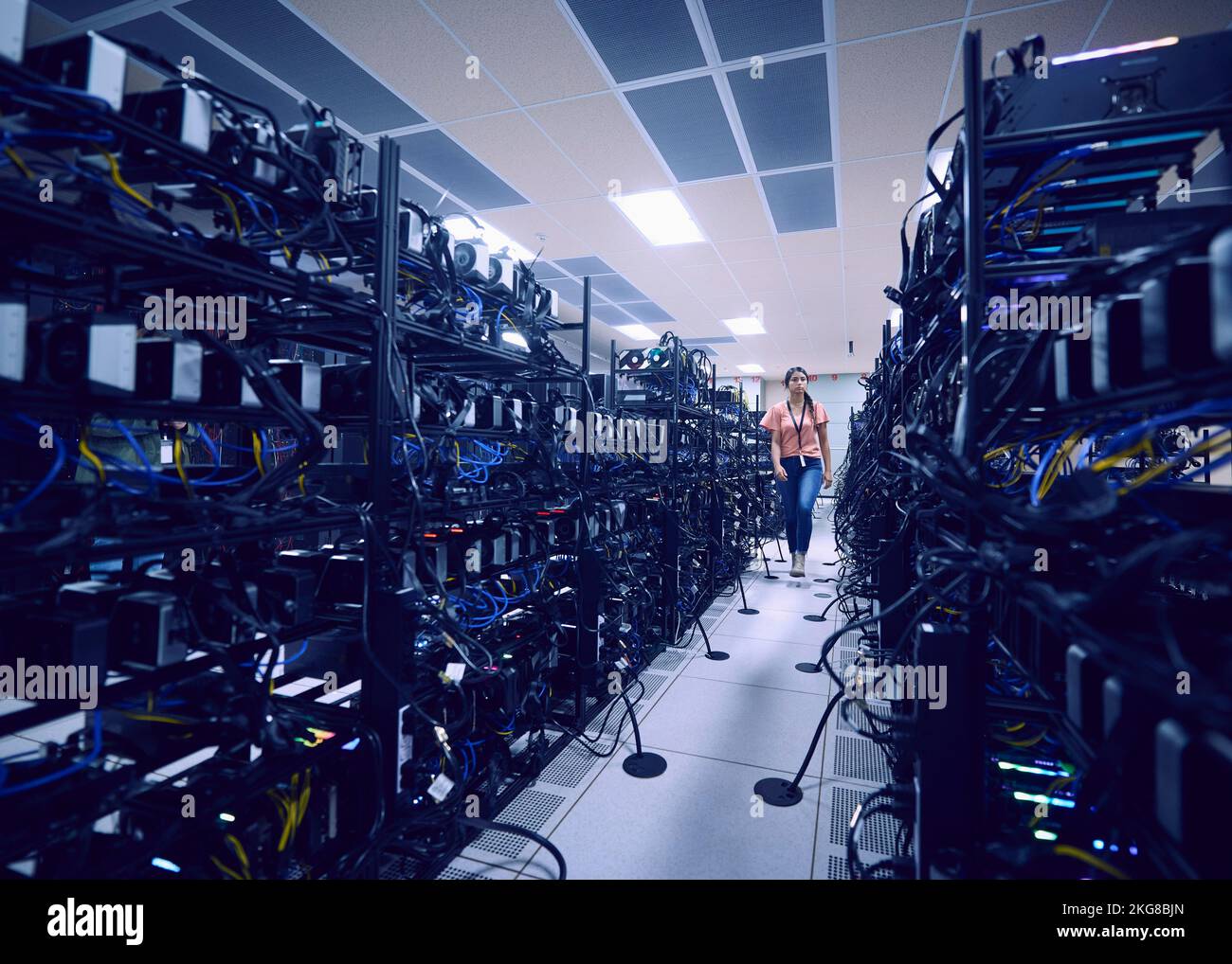 Female technician walking in server room Stock Photo