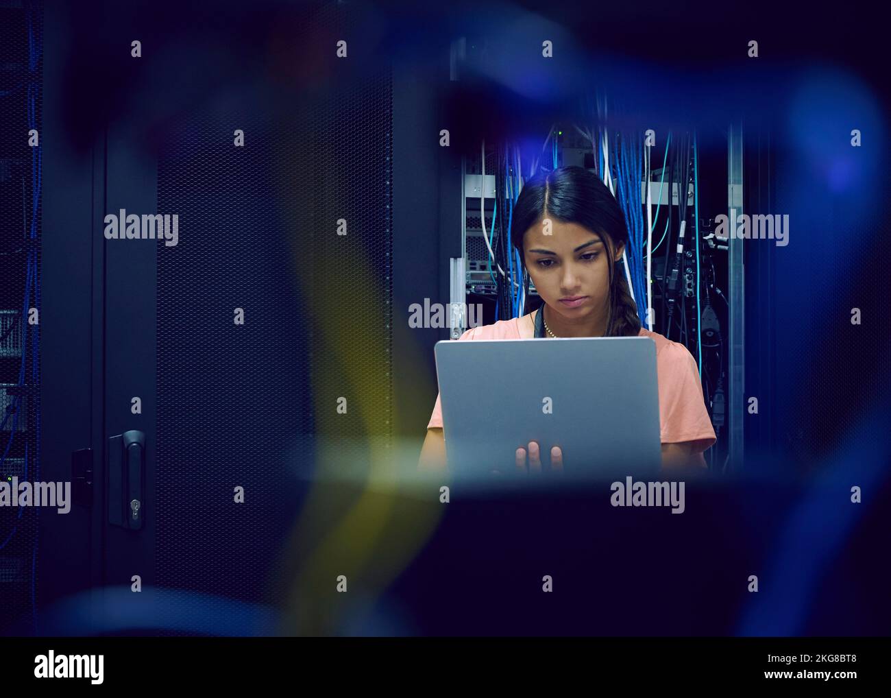 Female technician using laptop in server room Stock Photo