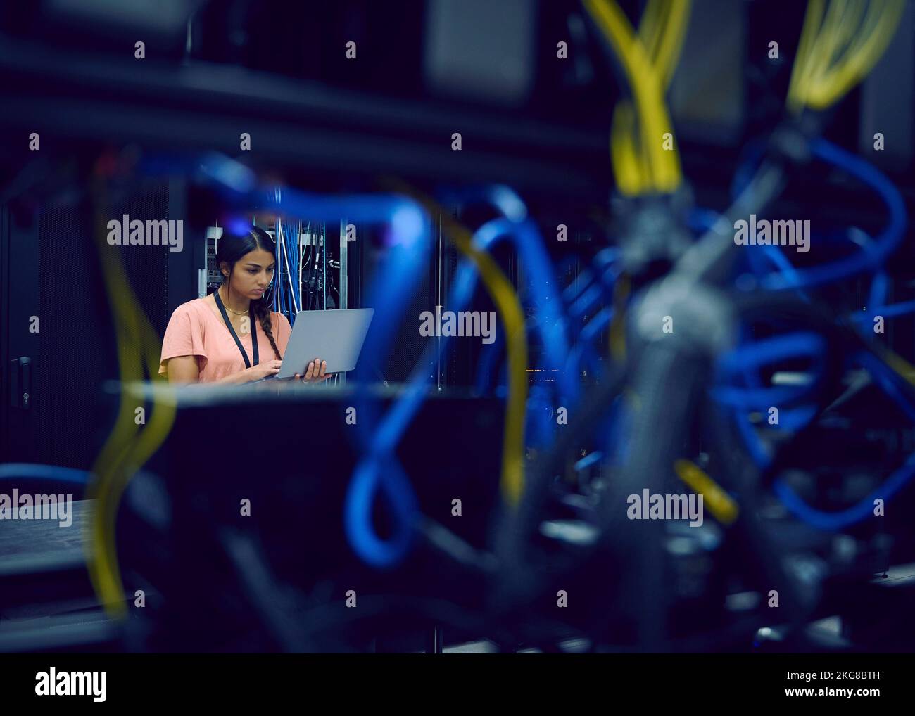 Female technician using laptop in server room Stock Photo