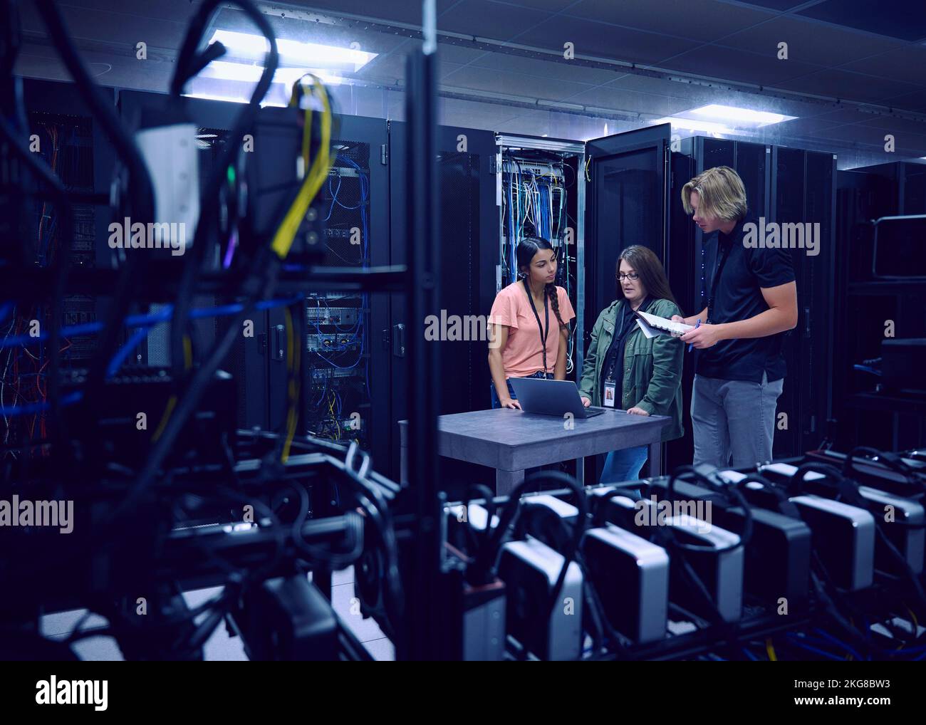 Team of technicians working in server room Stock Photo