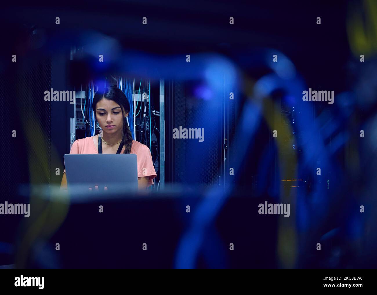 Female technician using laptop in server room Stock Photo