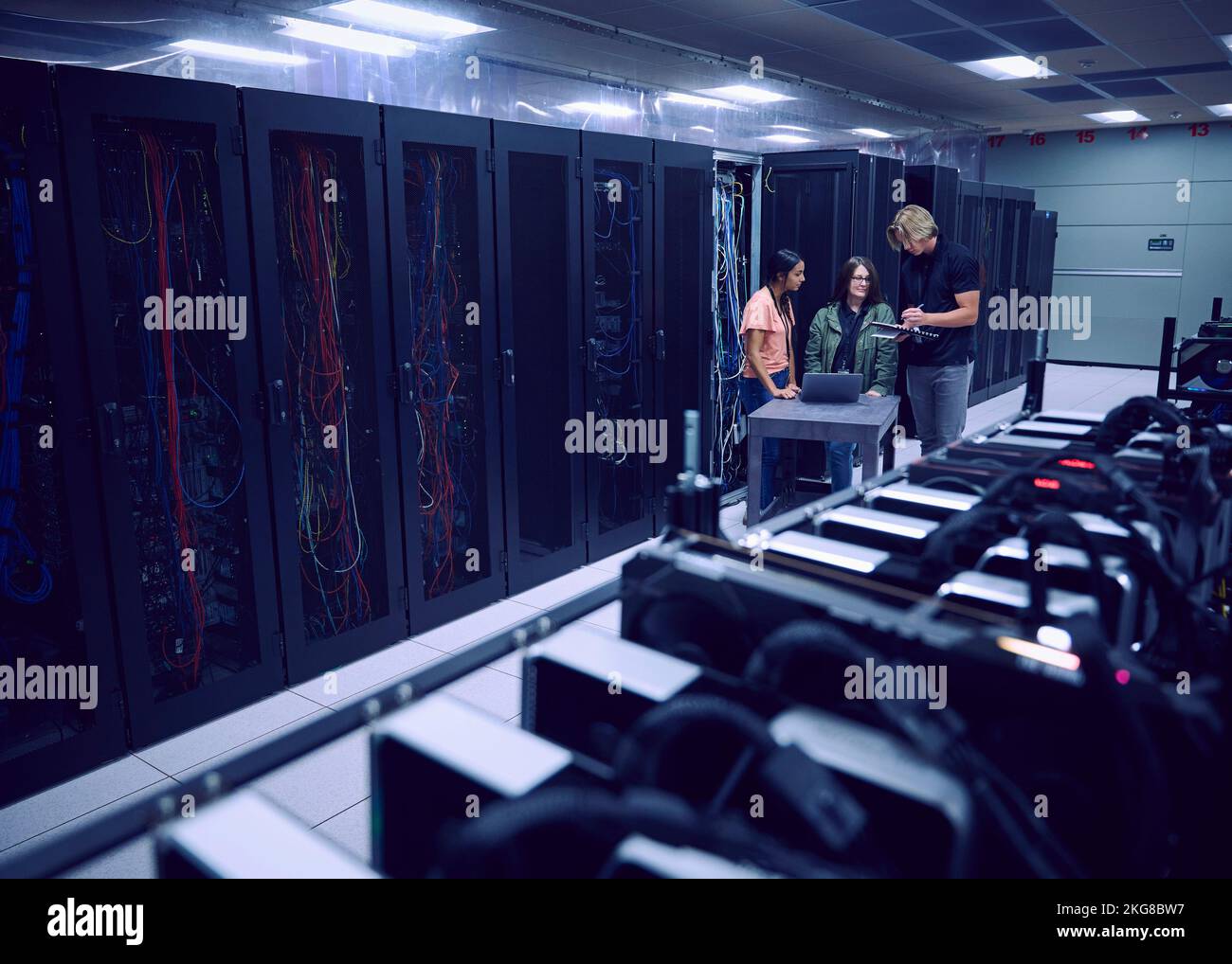 Team of technicians working in server room Stock Photo