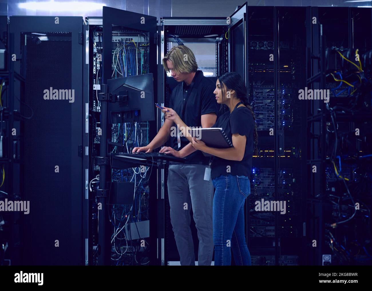 Technicians working in server room Stock Photo