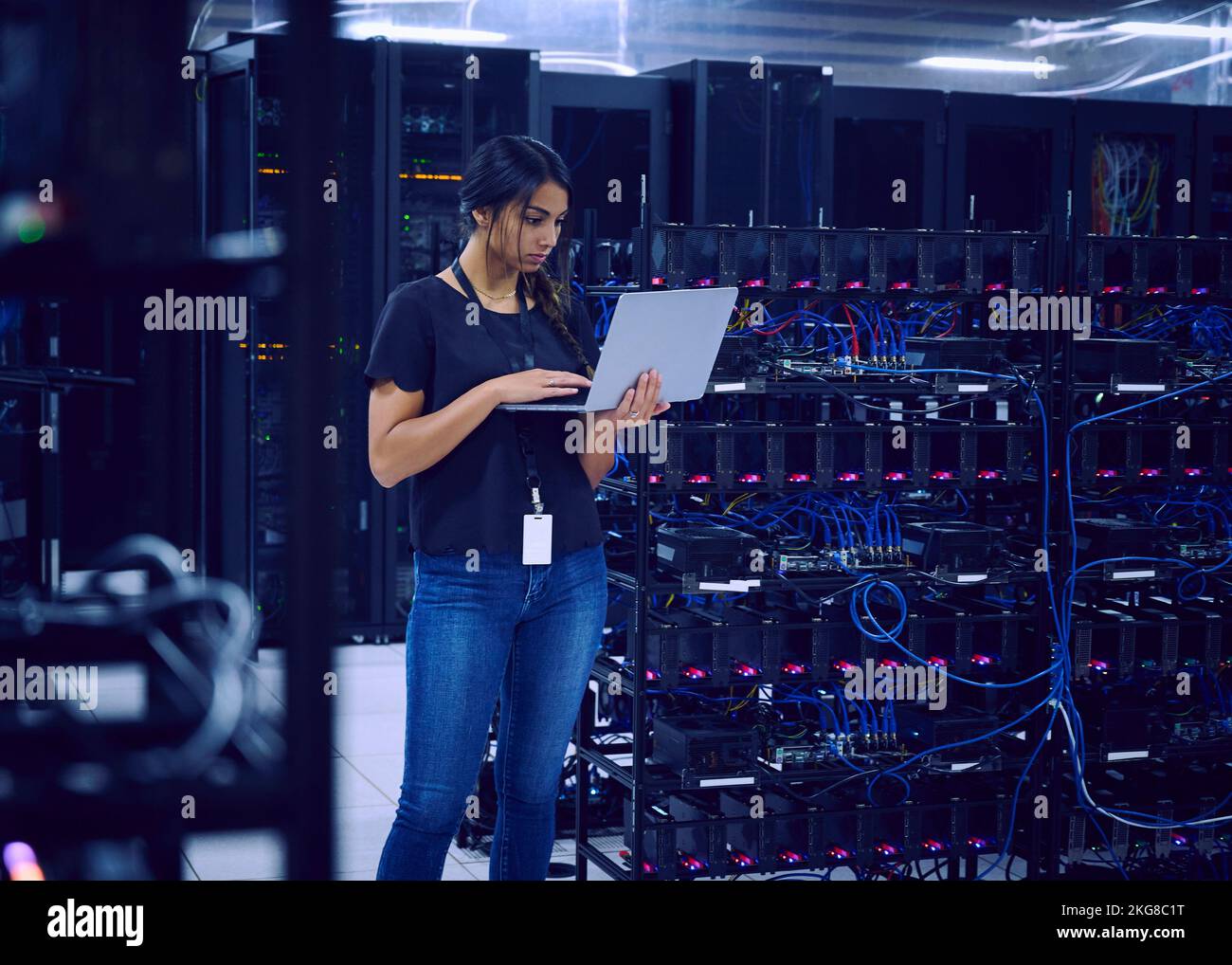 Female technician using laptop in server room Stock Photo