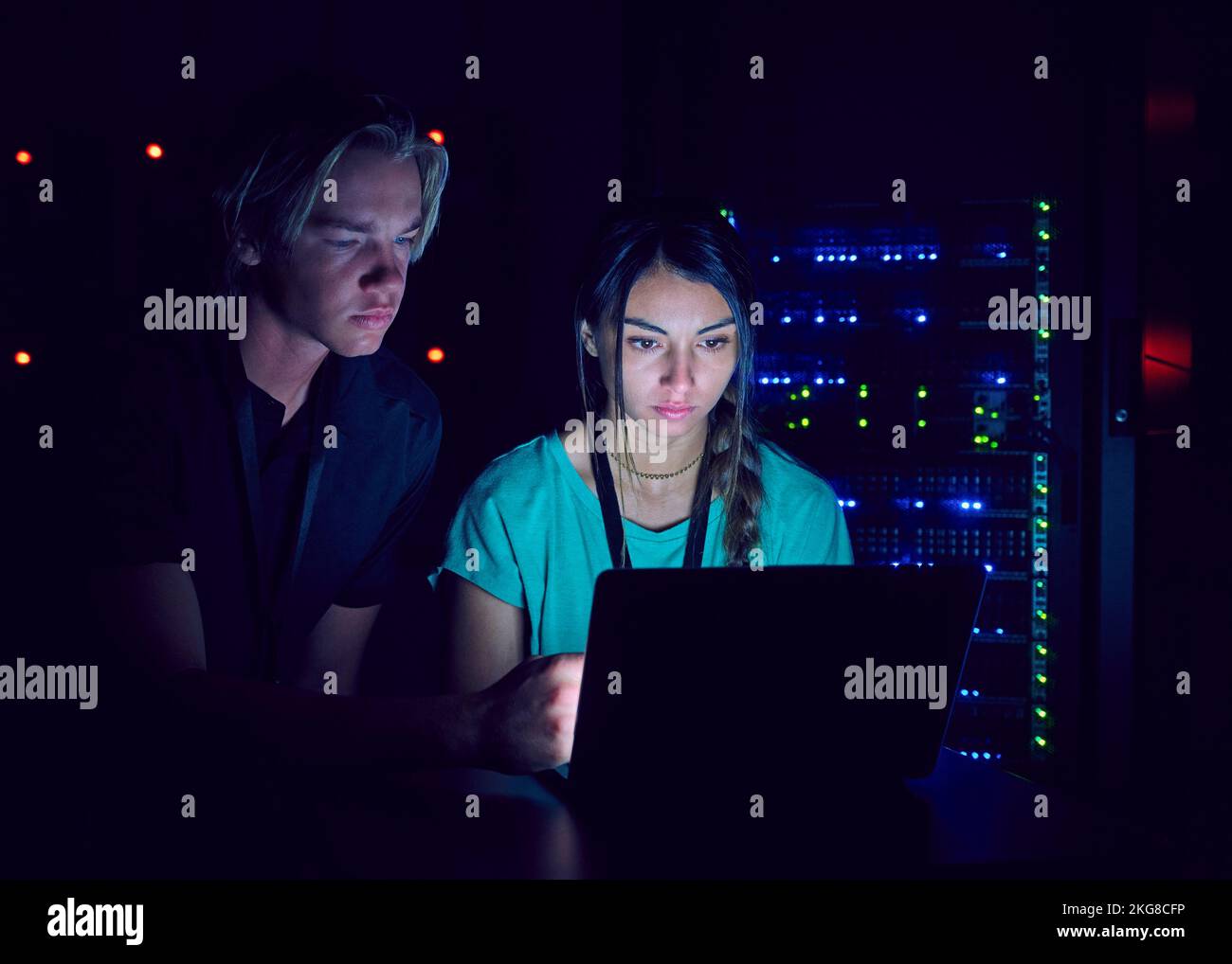 Technicians using laptop in server room Stock Photo