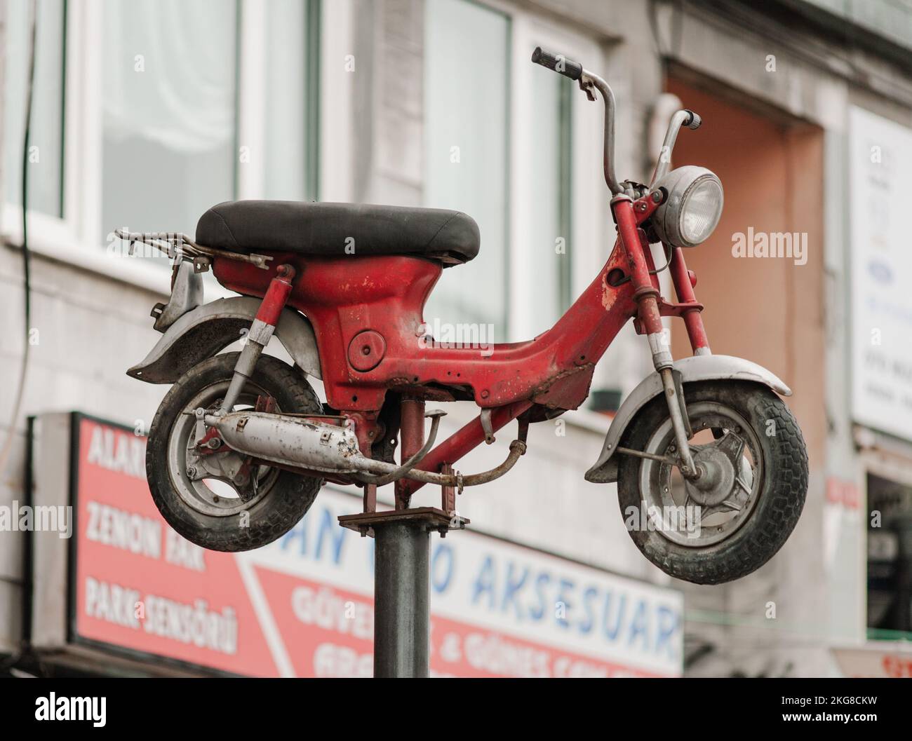 a retro moped is mounted on top of a rack for advertising Stock Photo