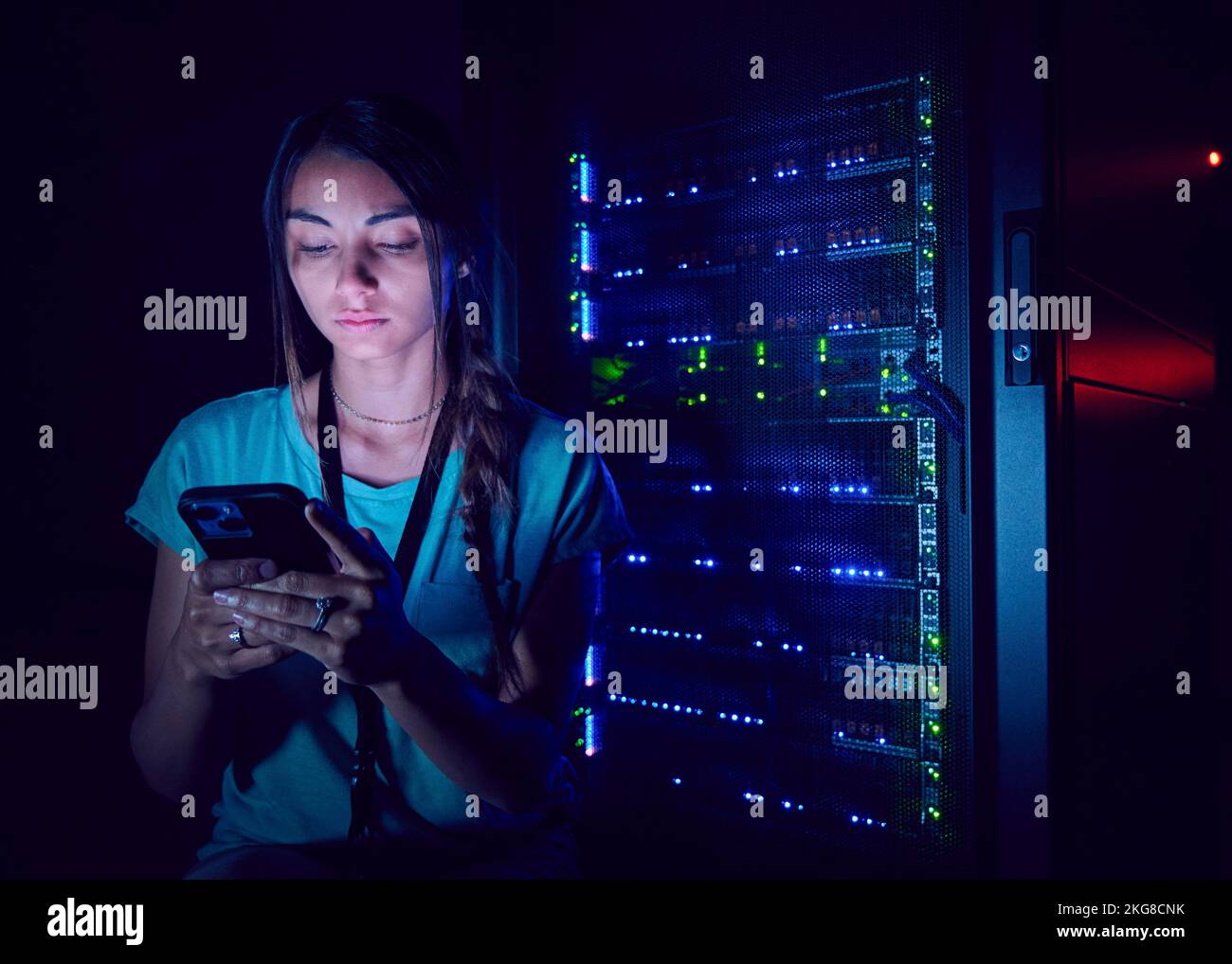 Technician using smart phone in server room Stock Photo
